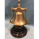 A C20th brass counter bell on turned hardwood stand, the bell from RMS Aquitania. (9in)