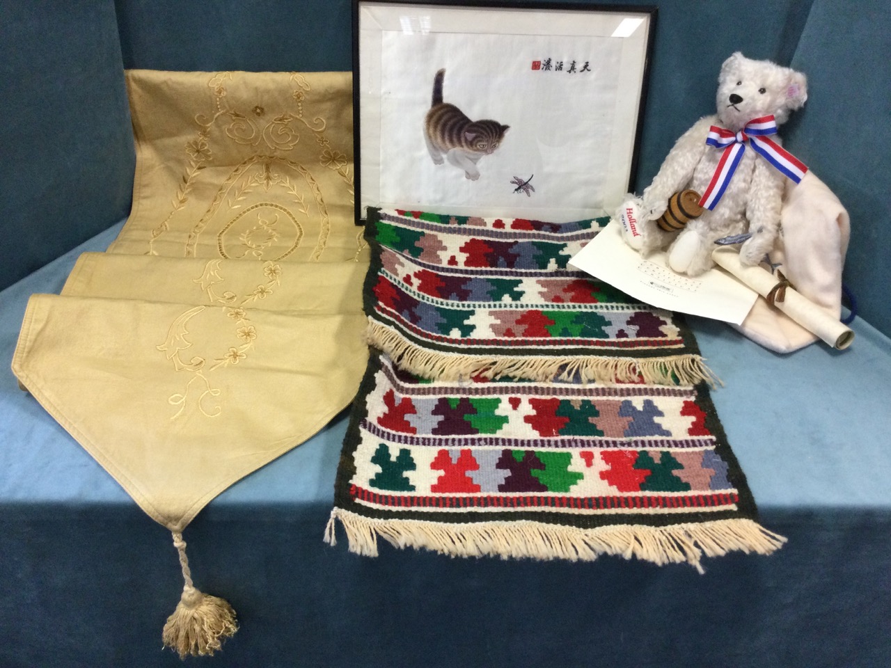 A bagged limited edition Steiff bear; an embroidered linen table runner; a brightly woven kelim; and