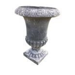 A large lead style garden urn with overhanging rim above tall lobbed body raised on sockle with