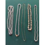 A string of pearls with an 18ct gold flowerhead clasp; another pearl necklace with circular silver