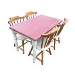 A reproduction pine kitchen table and four chairs, the rectangular moulded painted table top on