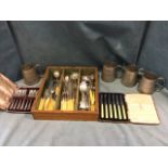 A set of four hammered tapering pewter tankards; and a tray of silver plated cutlery including a