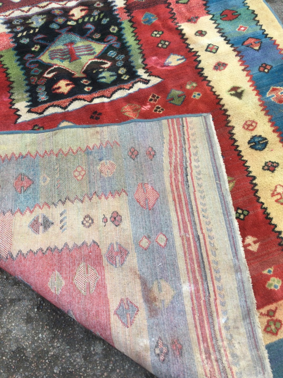 A contemporary wool rug woven with twin panels of hooked vases on red field framed by serrated - Image 3 of 3