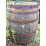 An oak whiskey barrel, the staves bound by six riveted metal strap bands. (33.5in)