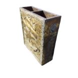 A rectangular brass stickstand with two divisions, embossed with galleon panel to front and