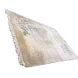 A Chinese thick pile wool carpet woven with embossed ivory floral frieze on mushroom ground, with