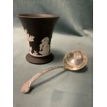 A hallmarked silver ladle with celtic decoration; and a black basalt Wedgwood cup with applied