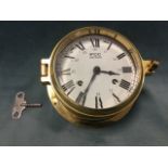 A boxed brass ships style bulkhead clock, the movement striking on bell, with enamelled dial