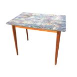 A 1970s kitchen table with decorative formica top, supported on tapering angled stained legs. (