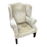 A Georgian style oak wing armchair with padded back and scrolled arms above a sprung seat, raised on