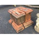 A square terracotta chimney pot formed from four square fluted moulded blocks supported on moulded