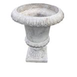 A classical style garden urn with lozenge moulded overhanging rim and lobbed body, supported on a