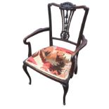 An Edwardian mahogany elbow chair, the scroll carved back with pierced splat decorated with shell