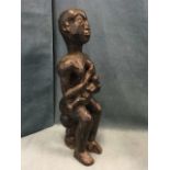 A carved hardwood figure of a seated mother & child, formed from one piece. (20in)