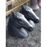 A pair of black painted composition stone horse heads - one ear missing. (20.25in) (2)