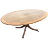An oval mahogany breakfast table, the crossbanded top inlaid with boxwood & ebony stringing