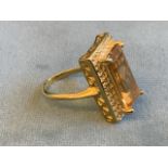 A citrine and zircon ring, the large rectangular claw set baguette cut citrine of approx 8.8 carats,