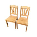 A pair of pine chairs with fan shaped splats beneath arched rails, having tapering seats on