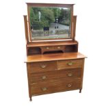 An Edwardian mahogany dressing table with bevelled mirror on rectangular supports above a platform
