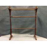 A Victorian towel stand with four rails on turned supports with ball finials, raised on shaped legs.
