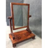 A Victorian mahogany dressing table mirror having cushion moulded frame on shaped supports, above
