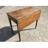 A nineteenth century country oak side table, the top with drop-leaf and gate, raised on square