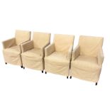 A set of four contemporary upholstered dining chairs with linen loose covers, raised on square
