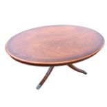 A mahogany coffee table, the oval moulded top inlaid with boxwood stringing on a turned column