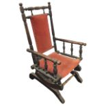 A Victorian childs rocking chair, the back with brass studded upholstered panel framed by ring-