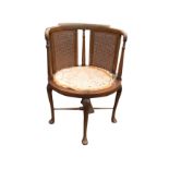 An oval mahogany occasional chair with rounded cane back panels framed by turned spindles, the