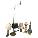 A brass standard lamp with shaped bracket for light, the column on circular cast iron weighted base;