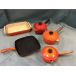 Three cast iron Le Creuset pans & covers, a rectangular baking dish and a ribbed frying pan. (5)