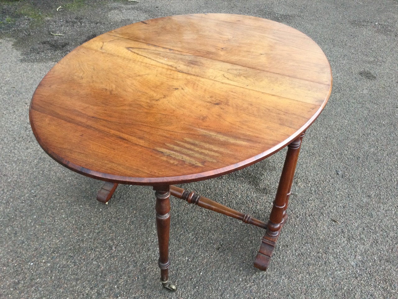 A Victorian walnut sutherland table with two rounded drop leaves forming an oval moulded top, - Bild 2 aus 3