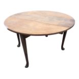 An oval Georgian mahogany dining table with two drop leaves supported on gate legs, the tapering