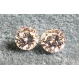 A pair of round brilliant cut diamonds, approx 0.25 carats each. (2)