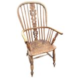 A nineteenth century elm windsor chair with hooped back above a pierced fiddle splat, having bow