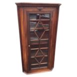 A Victorian mahogany corner cabinet with moulded dentil cornice above an astragal glazed door