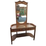 An Edwardian mahogany dressing table with bevelled mirror to back in shaped frame above a glass