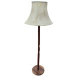 A teak standard lamp fitted with octagonal fabric shade, the turned column on circular moulded