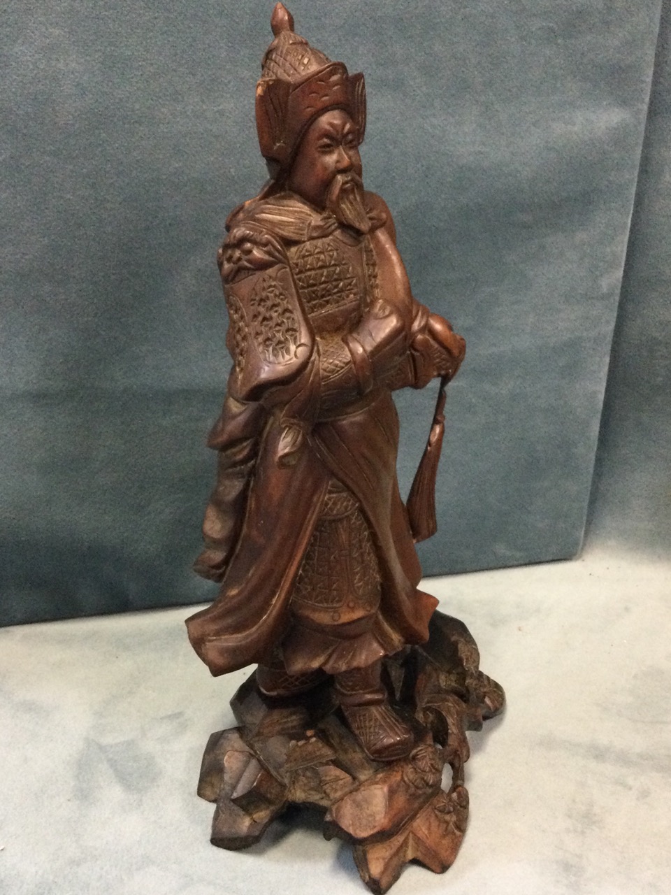 A Japanese carved figure of a warrior, the cloaked bearded man with stylised helmet having hand to - Bild 2 aus 3