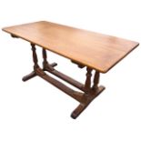 An oak refrectory table with rectangular top supported on twin turned columns joined by