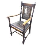 An oak armchair with cane panel to back framed by barleytwist columns with knob finials, having