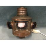 A D-shaped copper ships lamp with later conversion for electricity, having tubular chimney above a