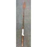 An African spear with sharp leaf shaped hammered blade on hardwood tapering shaft having cut chevron