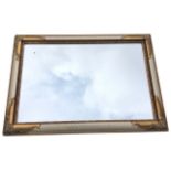A contemporary mirror in crackle-glazed frame, having leaf scroll embossed corners. (29.75in x 41.