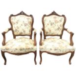 A pair of French walnut fauteuils, the upholstered shield shaped backs carved with gadrooned