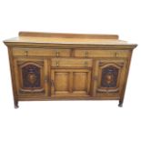 A late Victorian oak sideboard with rectangular moulded top above two long frieze drawers, the