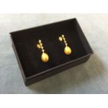 A pair of new boxed golden freshwater pearl drop earrings, the pearls suspended on cubic zirconia