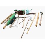 Miscellaneous garden tools and materials - scythes, pick axe, shovel, rolls of netting, canes,