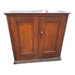 A Victorian mahogany cupboard with panelled doors enclosing an interior with shelves, with rounded